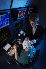 A human factors researcher applies electroencephalogram probes to participant