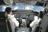 Two seated pilots commanding an aircraft en route